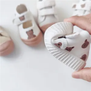 Close-up detail showing the soft and flexible sole of white canvas baby bear shoes.