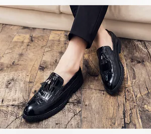Gros plan de mocassins Brogue en cuir verni noir avec glands et détails richelieu