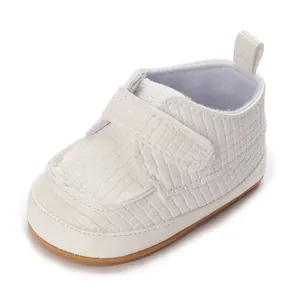 Dettaglio di scarpa bianca da neonato per primi passi con trama intrecciata e velcro