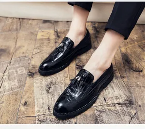 Gros plan de mocassins richelieu noirs avec pompons et motifs sculptés sur sol vintage