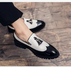 Gros plan de mocassins brogue en cuir noir et blanc avec décor de glands
