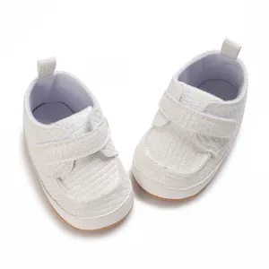 Vista dall'alto di scarpe primi passi per neonati bianche con trama intrecciata e velcro