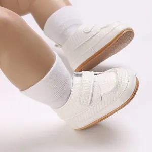 Primo piano di sneakers bianche per neonati con suole marroni morbide e calzini bianchi