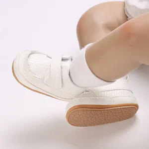 Dettaglio scarpe da camminata bianche per neonati con suola in gomma morbida antiscivolo testurizzata