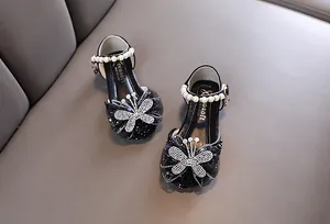 Detailansicht von schwarzen Mädchen Prinzessinnenschuhen mit Strass Schmetterling und Perlen
