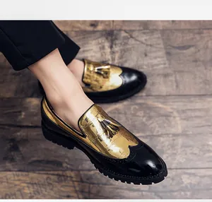 Vue détaillée de mocassins brogue homme dorés et noirs avec des accents de glands
