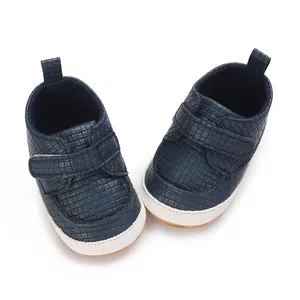 Vista dettagliata di scarpe da neonato blu scuro intrecciate con suole bianche morbide