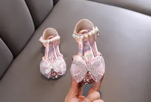 Nahaufnahme rosa Mädchen Prinzessinnenschuhe mit Strass-Schmetterling und Perlenbesatz