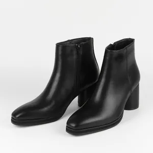 Close-up of black high-heeled ankle boots with side zipper and square toe design.