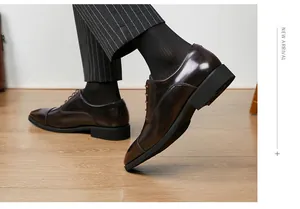 Detail view of polished burgundy leather cap-toe Oxford shoes for formal business attire