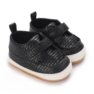 Dettaglio di scarpe da ginnastica nere testurizzate per neonati con suola morbida e velcro
