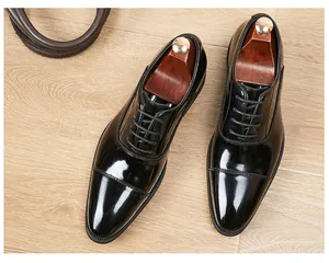 Top-down view of glossy black leather cap-toe Oxford shoes for business wear