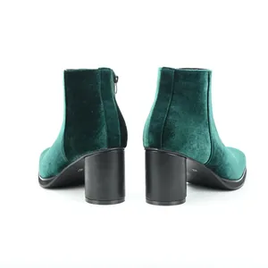Detailed rear view of dark green velvet ankle boots featuring a black chunky block heel