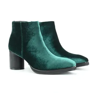 Side view of elegant bold emerald green velvet Chelsea boots with black chunky heels