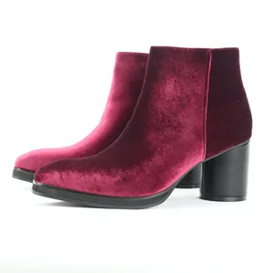 Detail view of wine red velvet ankle boots featuring a chunky black block heel