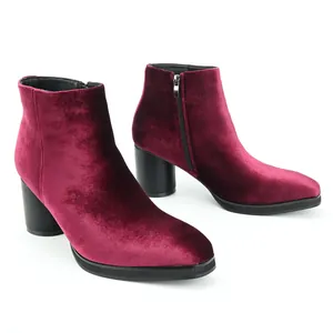 Close-up view of elegant burgundy velvet ankle boots with side zippers and chunky heels