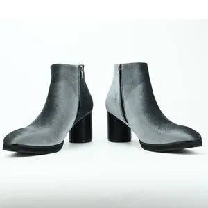 Side profile detail of grey velvet ankle boots with chunky heels and side zipper closure