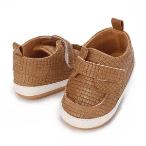 Primo piano di scarpe primi passi per neonati in pelle PU marrone con chiusura a strappo