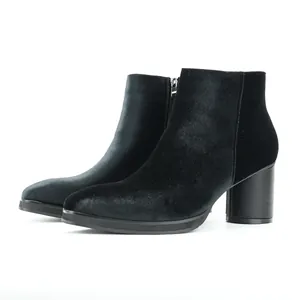 Close-up view showing the black velvet texture and chunky heel of these Chelsea boots.