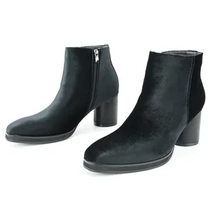 Side view of black velvet ankle boots with side zipper and chunky block heel detail