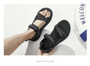 Detailopname van zwarte heren sportsandalen met verstelbare klittenband op witte achtergrond.