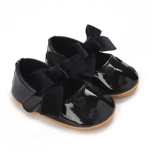Dettaglio di scarpe da principessa per neonata con fiocco di velluto