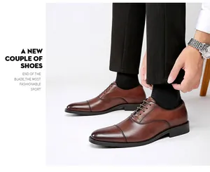 Side profile detail of brown leather Oxford shoes worn with black trousers.