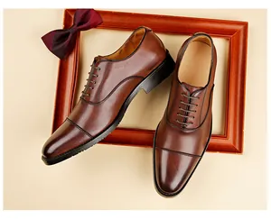 Top-down view of premium brown leather Oxford shoes with cap-toe detail and wooden frame