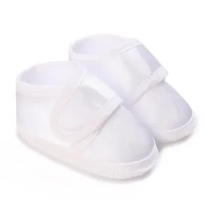 Detail view of white satin baby baptism shoes with soft soles and velcro strap