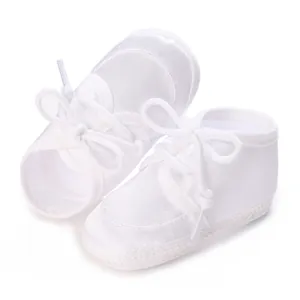 Detailansicht weißer Taufschuhe für Babys mit weichen Schnürsenkeln und Stoff