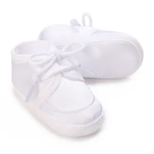 Detailansicht von weißen Taufschuhen aus Satin für Babys im Alter von 0-1 Jahr.