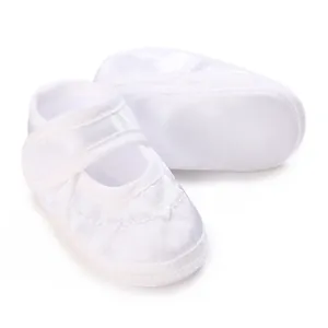 Detailaufnahme der weißen Satin-Babyschuhe für die Taufe mit Klettverschlussriemen