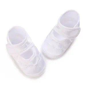 Detailansicht der weißen Taufschuhe aus Satin mit Stickerei und Klettverschluss