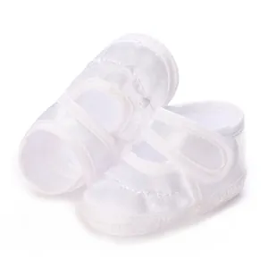 Nahaufnahme weißer Satin-Babytaufschuhe mit dezentem besticktem Herzmuster-Detail