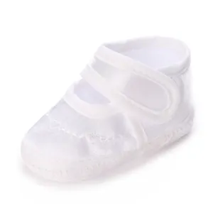 Vue détaillée de chaussures de baptême en satin blanc pour bébé avec bride velcro