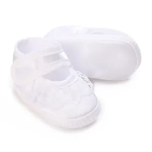 Detailed view of white lace baby baptism shoes with hook-and-loop strap for infants.