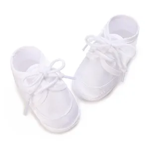 Elegant white infant baptism shoes with delicate lace-up design for ceremonies