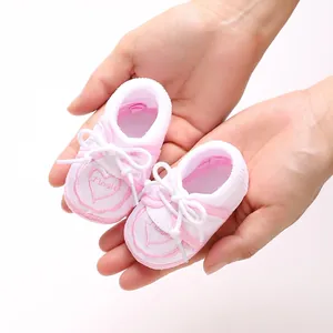 Detailed close-up of pink and white baby floor socks featuring heart embroidery and a white bow