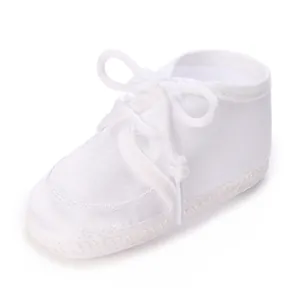Vue détaillée d'une chaussure de baptême blanche en satin avec lacets doux