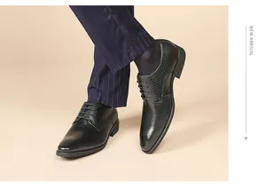 Close-up of black embossed leather Derby shoes worn with formal pinstripe trousers