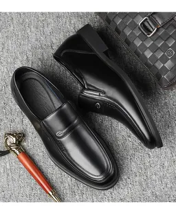 High-quality detail of black leather men's slip-on business dress shoes with accessories