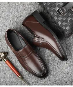Top-down view of classic brown leather loafers with decorative metal accents.