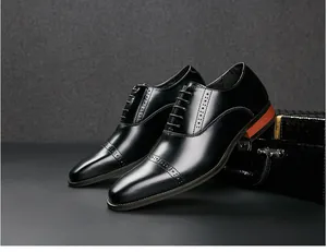 Close-up of black leather Oxford shoes with elegant brogue perforation details.