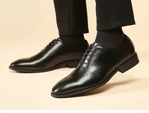 Primer plano de elegantes zapatos Brogue para hombre en cuero negro con calado wingtip.