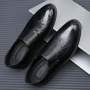 Nahaufnahme hochwertiger Herren-Business-Loafer aus schwarzem Leder vor Laptop-Hintergrund