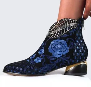 Détail de la broderie florale bleue et des feuilles en strass sur la bottine ethnique.