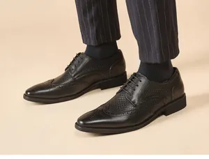 Detailed view of men's black leather brogue shoes with wingtip carving and lace-up design