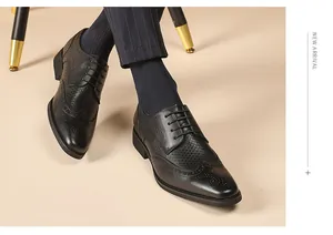 Close-up shot of black leather brogue shoes featuring intricate carved wingtip details.