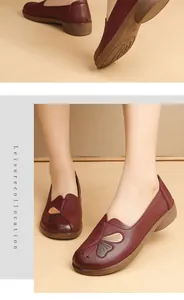 Detailed view of burgundy comfort flat shoes with butterfly design worn by a model