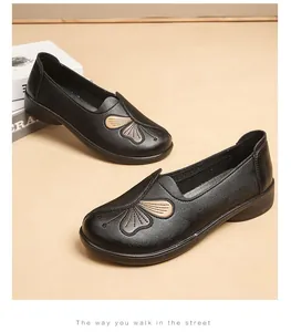 Detailed view of the butterfly embroidery on these black leather comfort flats for women.